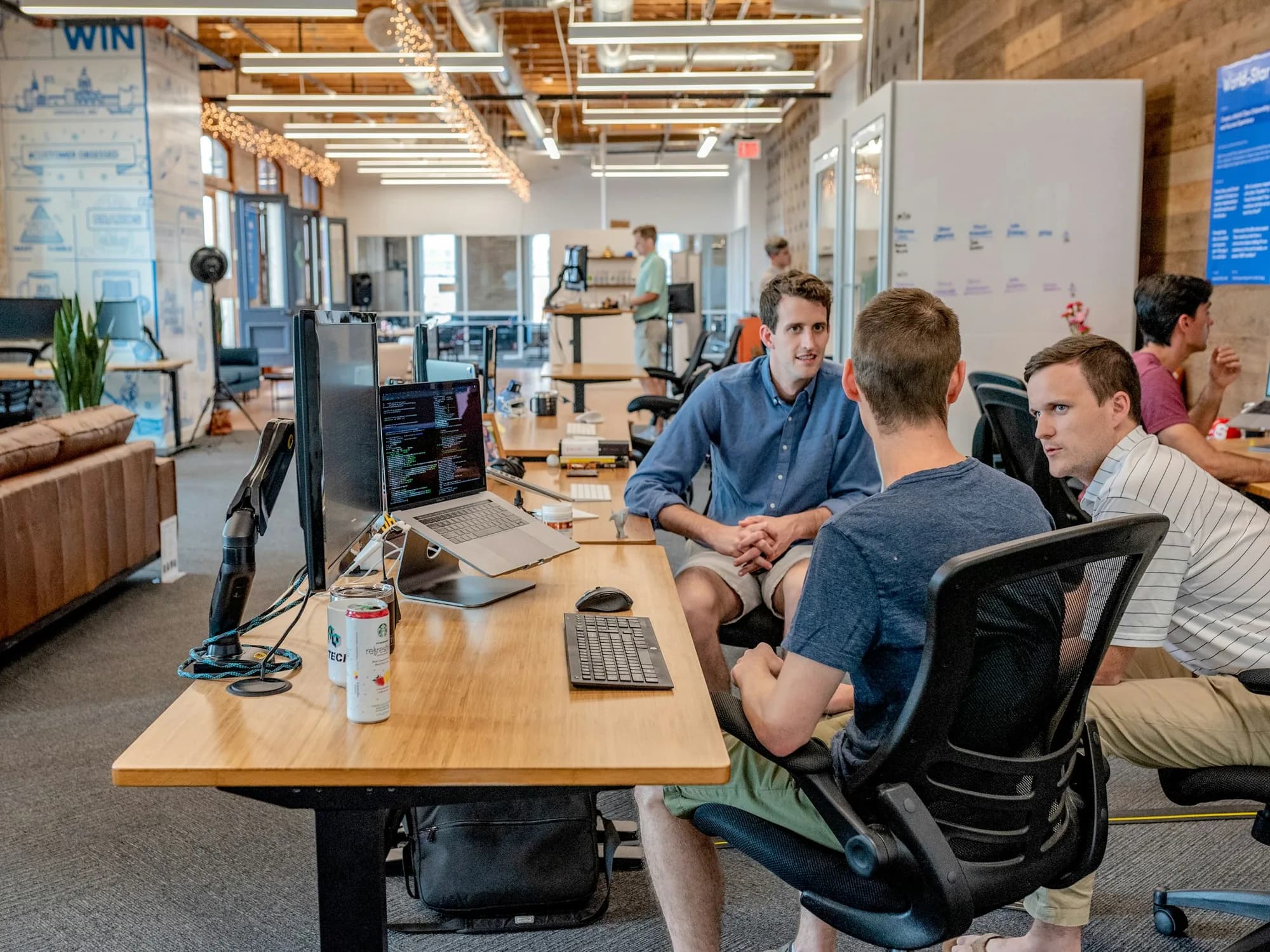 Colleagues working together around desks in an open-plan office
