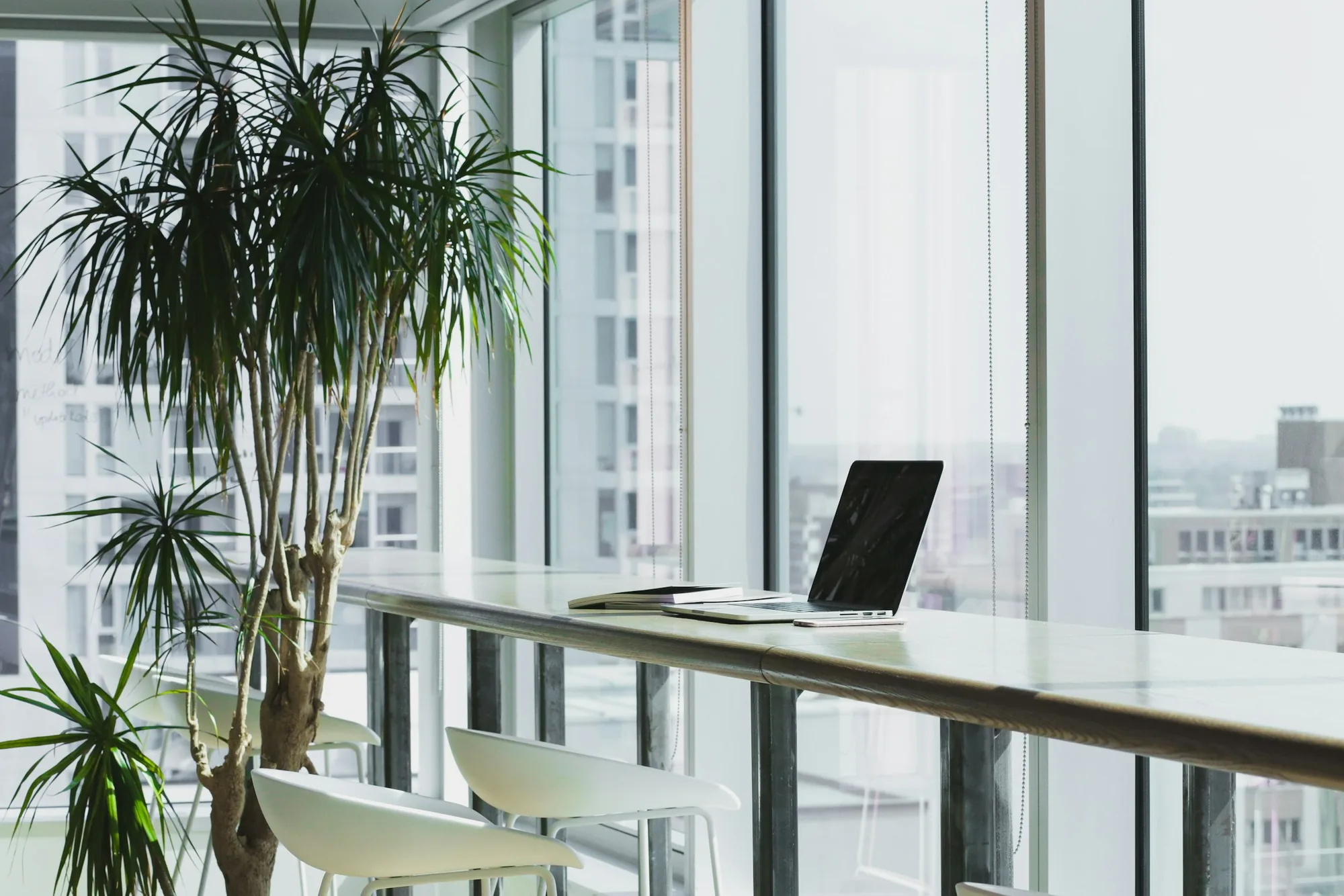 Bright office workspace beside floor-to-ceiling windows